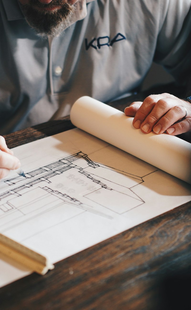 Consultant reviewing building plans at a desk