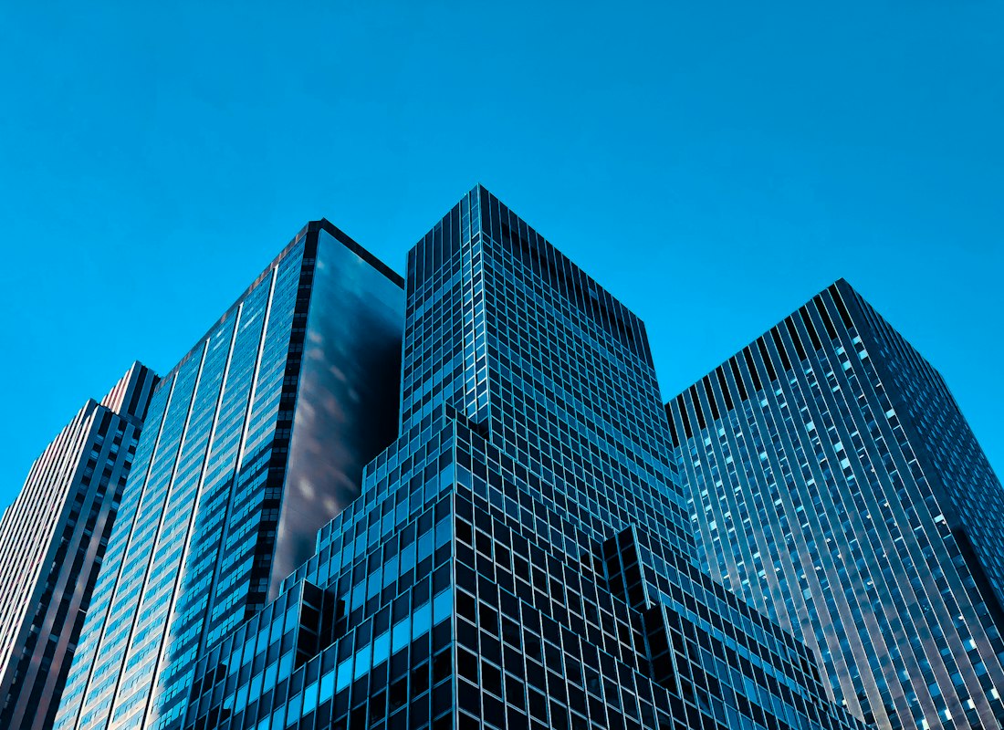 Modern glass office building against a blue sky